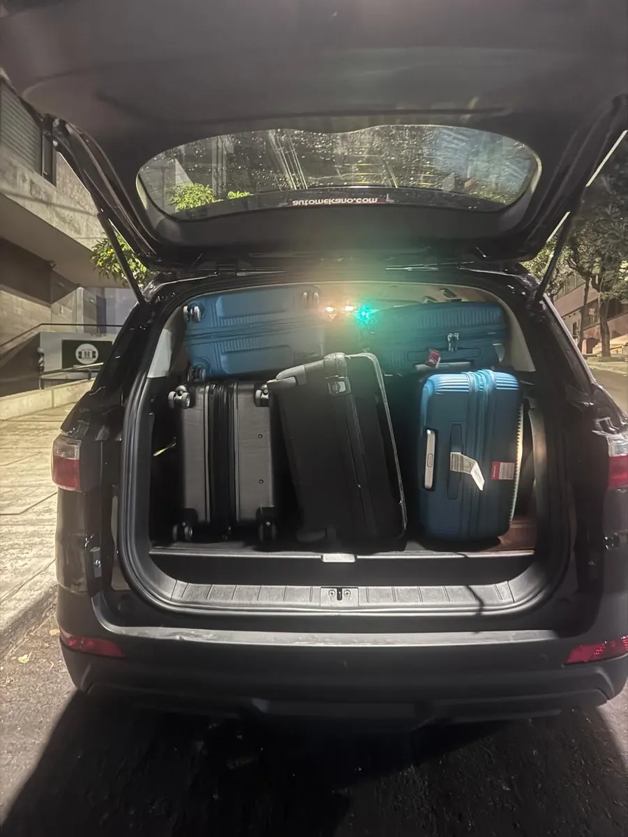 SUV trunk loaded with four suitcases